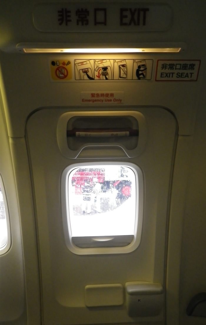 Interior view of a 737 Type III overwing emergency exit, showing the pull handle, exit signage and safety placard